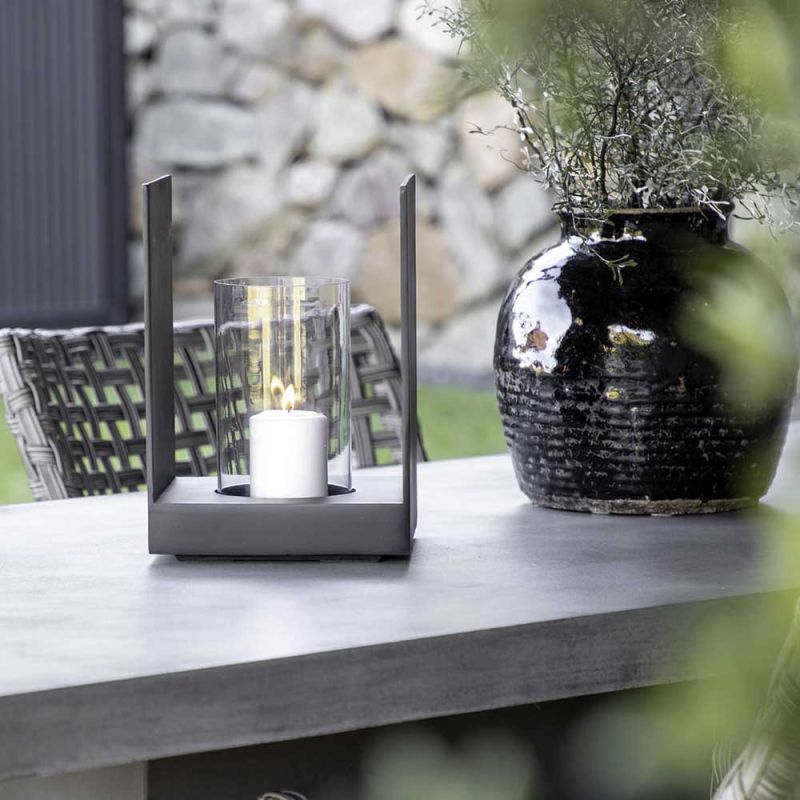 Small lantern half exposed with black aluminium panels and glass candleholder