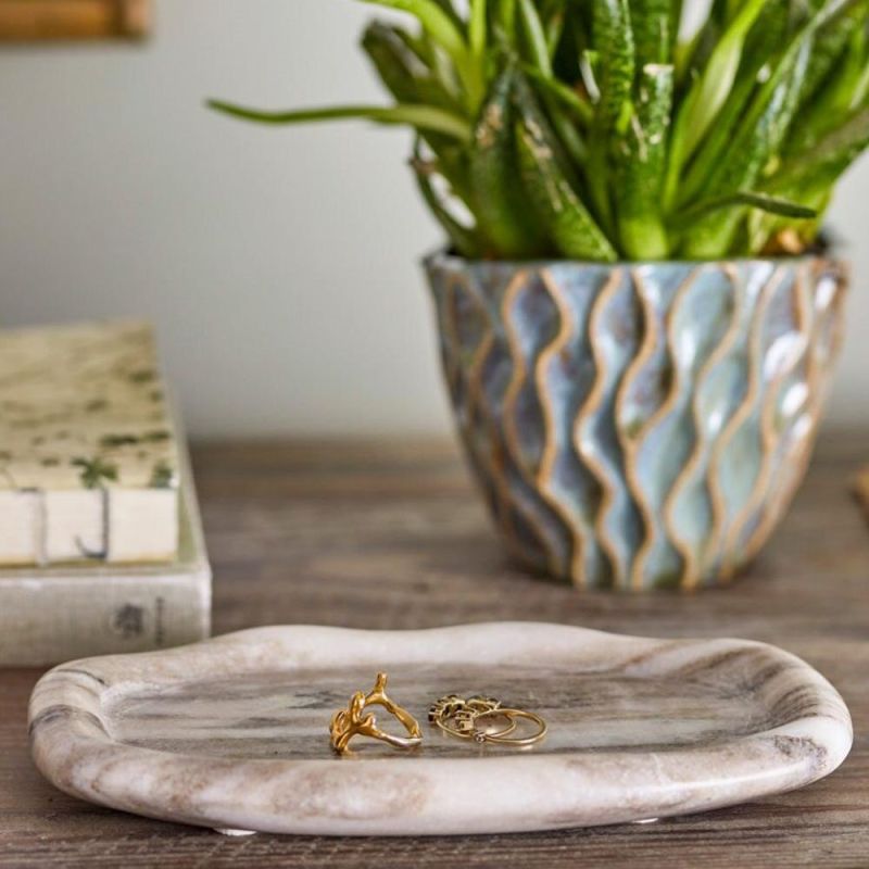 Light marble tray with raised edge and naturally curved shape