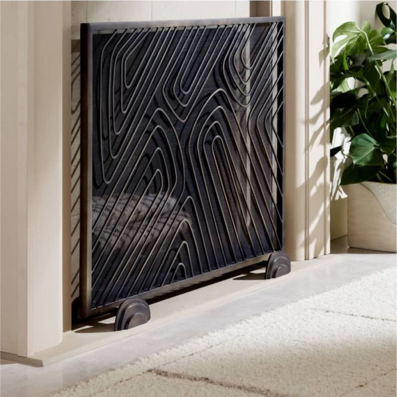 A bronze iron firescreen with fingerprint-inspired patterns and pebble-shaped feet for stability.