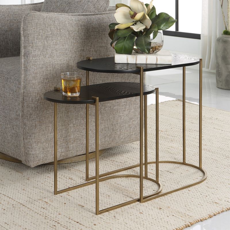 A glamorous set of nesting tables by Uttermost with oval tops and an antique brass finish