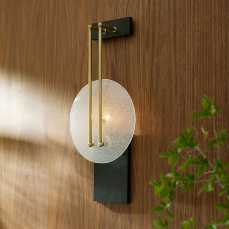 Elegant sconce light with slim brass metalwork and frosted grass