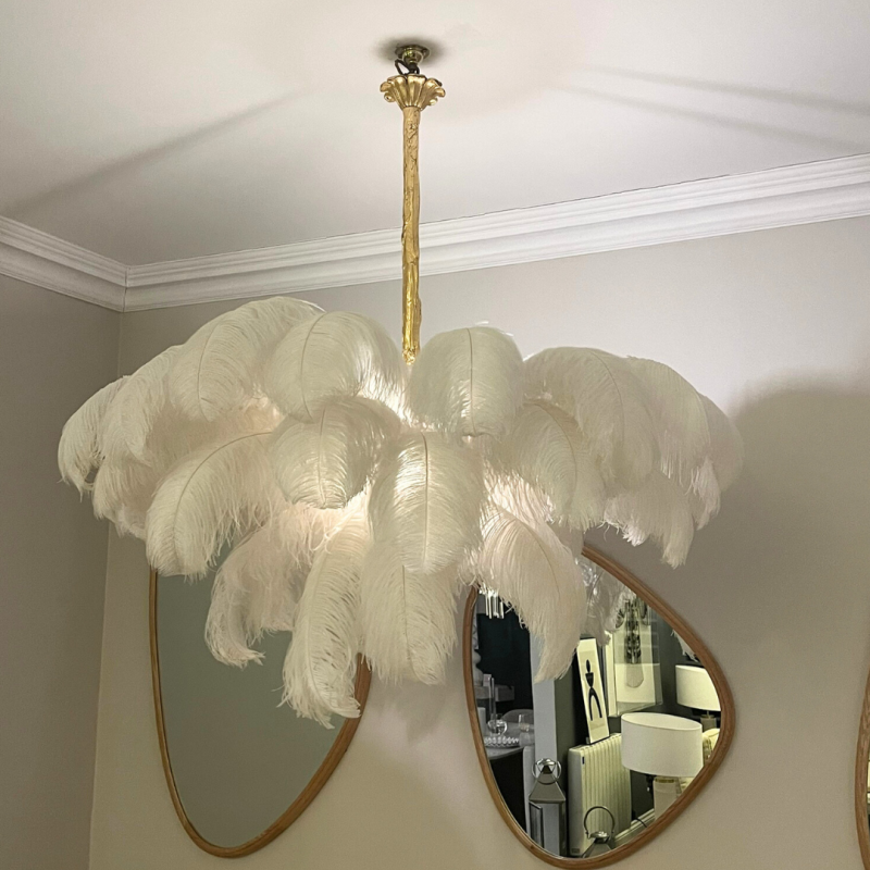 White ostrich feather chandelier with gold fixture.