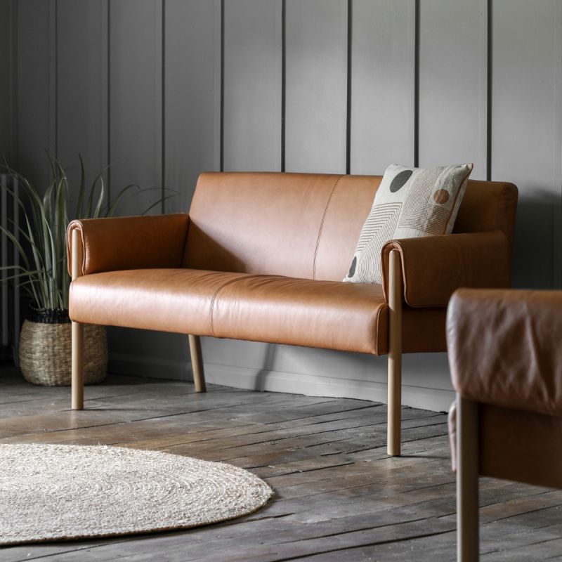 Brown leather two-seater sofa with unique folded arm silhouette and wooden frame