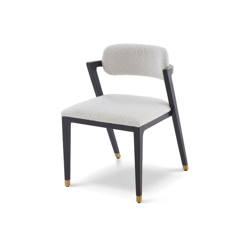 Boucle upholstered dining chair with slanted black legs and brass caps on the feet