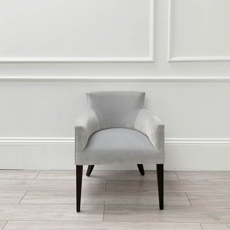 Sumptuous grey velvet chair with black, tapered back legs and pen mark on bottom of backrest 