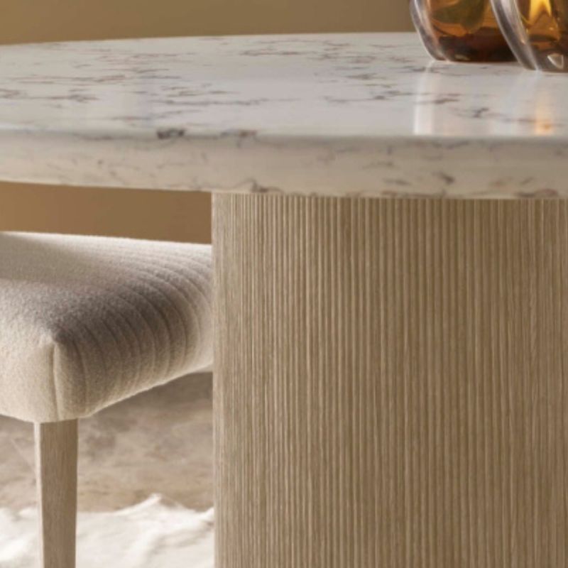 Dining table with ribbed light wood base and round white marble top