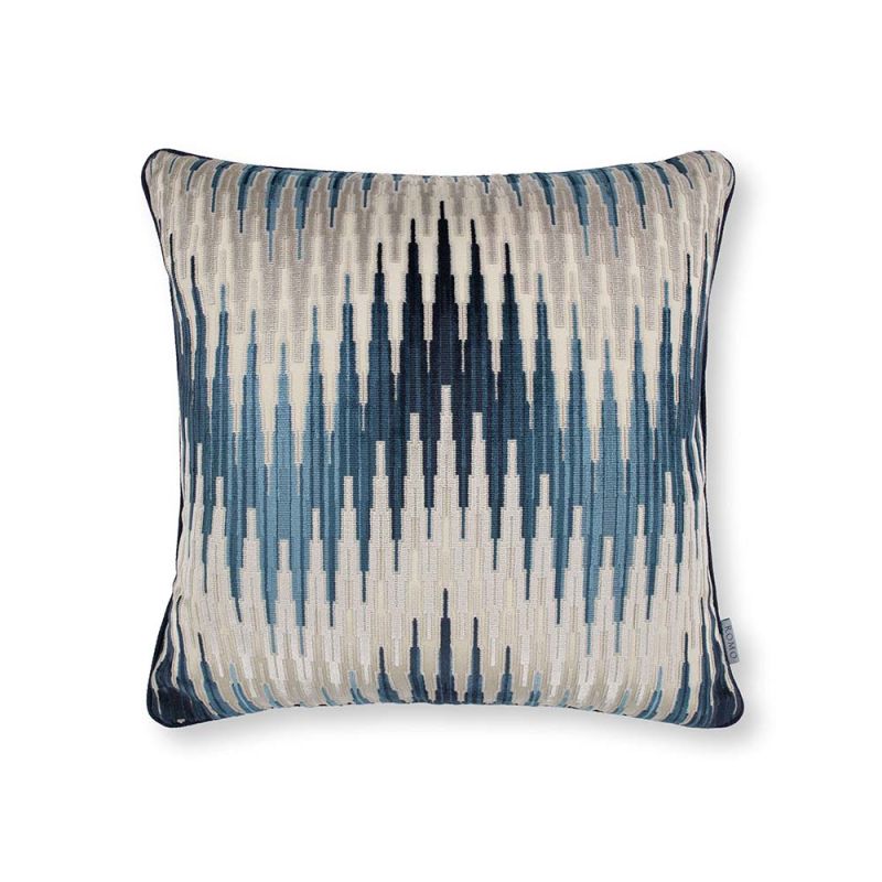 A cushion with a velvet chevron pattern in blue and cream hues.