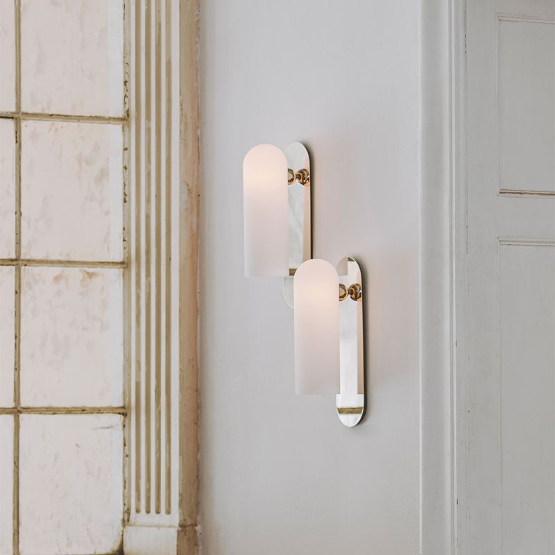 Contemporary solid brass wall lamp in a polished nickel finish with a long translucent glass lampshade