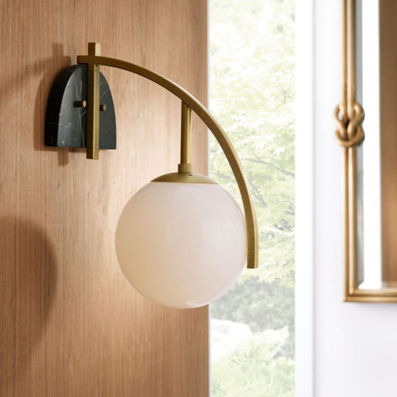 Sleek wall sconce with a backplate of black marble and opal glass globe