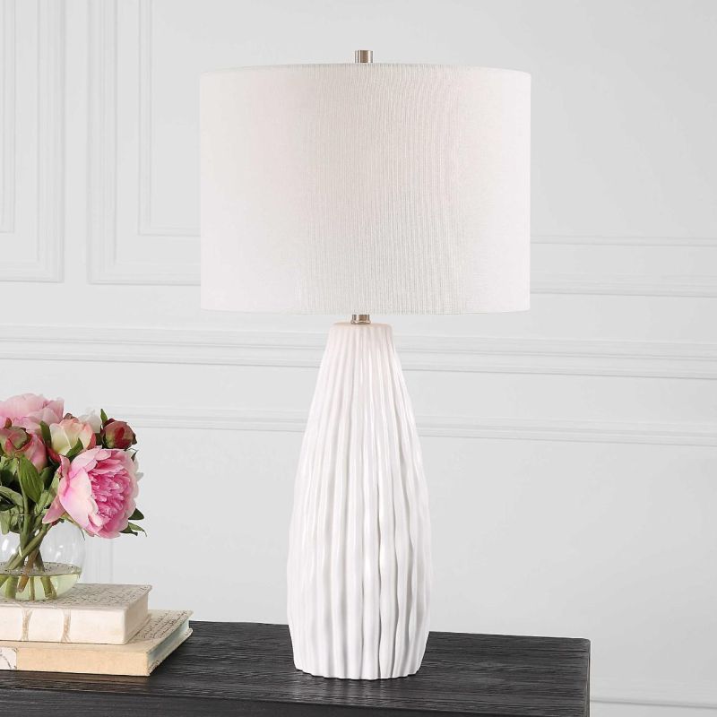 This ceramic lamp features a textured satin white finish, brushed nickel accents, and a white linen shade, adding elegance and simplicity to any room.