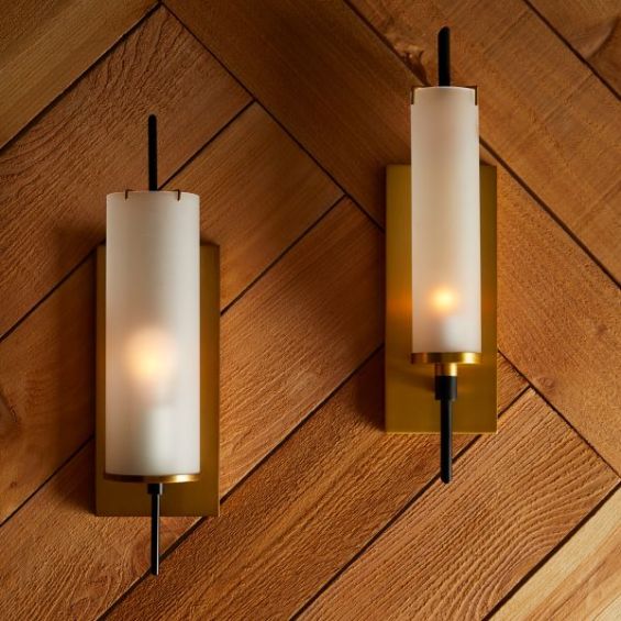 Cylindrical wall sconce mounted on brass panel base