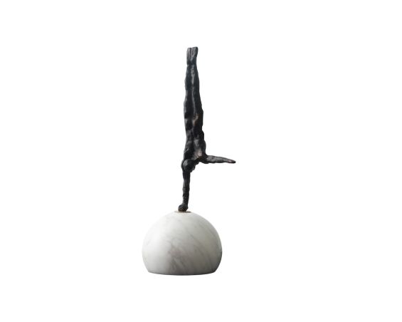 Sculpture of man handstand on marble ball