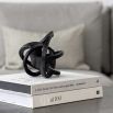 Abstract intertwined black metal sculpture