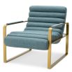 blue linen upholstered armchair with horizontal fluting and brass frame