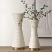 Ridged cream vases with curvaceous silhouette.