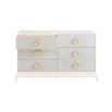 A six drawer dresser with light blue raffia drawer fronts, brass hardware and an ivory lacquered mahogany frame.