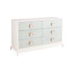 A six drawer dresser with light blue raffia drawer fronts, brass hardware and an ivory lacquered mahogany frame.