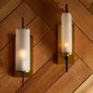 Cylindrical wall sconce mounted on brass panel base