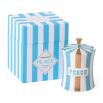 A glamorous candle by Jonathan Adler with a blue and brass finished peace vice canister