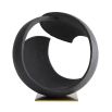 Round black stone sculpture on brass base