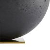 Round black stone sculpture on brass base