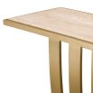 Brushed brass console table with a structured base and travertine top. 