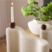 Set of three sculptural candleholders in cream with naturally textured surfaces and wooden accents.