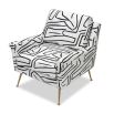 Square shaped lounge chair upholstered in black and white graphic print with brass legs