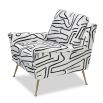 Square shaped lounge chair upholstered in black and white graphic print with brass legs