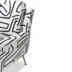 Square shaped lounge chair upholstered in black and white graphic print with brass legs