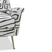 Square shaped lounge chair upholstered in black and white graphic print with brass legs