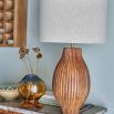 Lamp with carved mango wood base and light linen shade