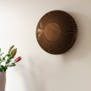 Round wall sconce with a delicate cut-out wooden surround