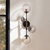 Wall sconce with four glass smoked globes feature lights fitting in a black frame