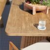 Rectangular teak dining table with two wide rattan legs and a supporting beam