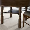 Circular wooden finish dining table with ribbed detailing and bronze finished fixings.