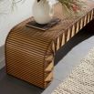 Curved wooden bench with strands of woven leather