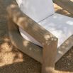 Outdoor dining chair with a thick wooden frame and white cushions