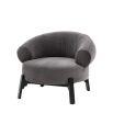 Armchair with curved wrap around back and round seat supported by dark wood base frame and legs