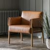 Brown leather armchair with unique folded arm silhouette and wooden frame