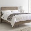 Light wooden superking size bed with cross pattern on headboard