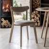 Contemporary wooden dining chair with gently curved back rails upholstered in lovely neutral fabric