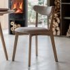 Contemporary wooden dining chair with gently curved back rails upholstered in lovely neutral fabric