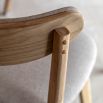 Contemporary wooden dining chair with gently curved back rails upholstered in lovely neutral fabric