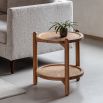 Circular wooden side table with lower rattan shelf