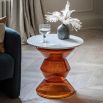 Glass-based side table with sculptural silhouette and round marble top