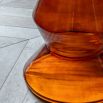 Glass-based side table with sculptural silhouette and round marble top