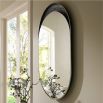 The Inset Wall Mirror features a smooth, glossy surface within a textured bronze-plated aluminium frame, offering versatile display options and unique variations in finish.