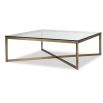 Brass frame coffee table supporting clear glass top