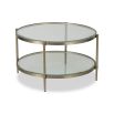 Sturdy coffee table with circular frame, brushed brass finish and glass top